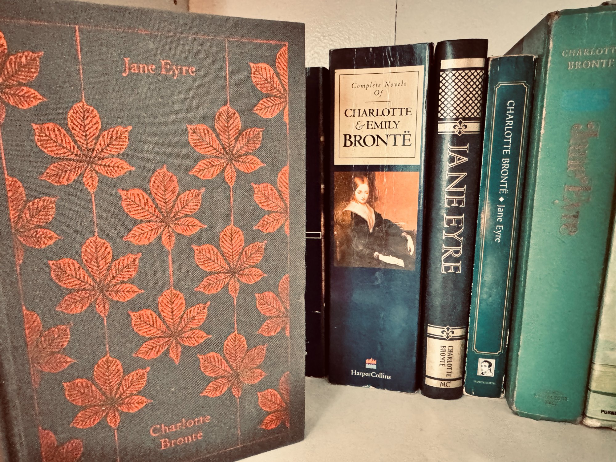 A shelf of Jane Eyre editions including a Penguin clothbound classic, HarperCollins complete Bront novels, and vintage hardcovers